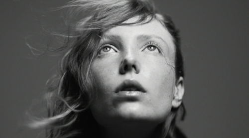 Ablack and white foto of a female model looking up into the sky taken with an old vintage Zeiss Highspeed lens.