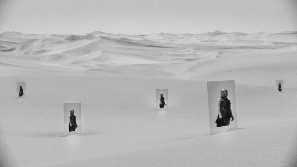 Abstract black and white collage of a woman in a sand dessert. Soft low contrast look thanks to Cooke Varotal lens.