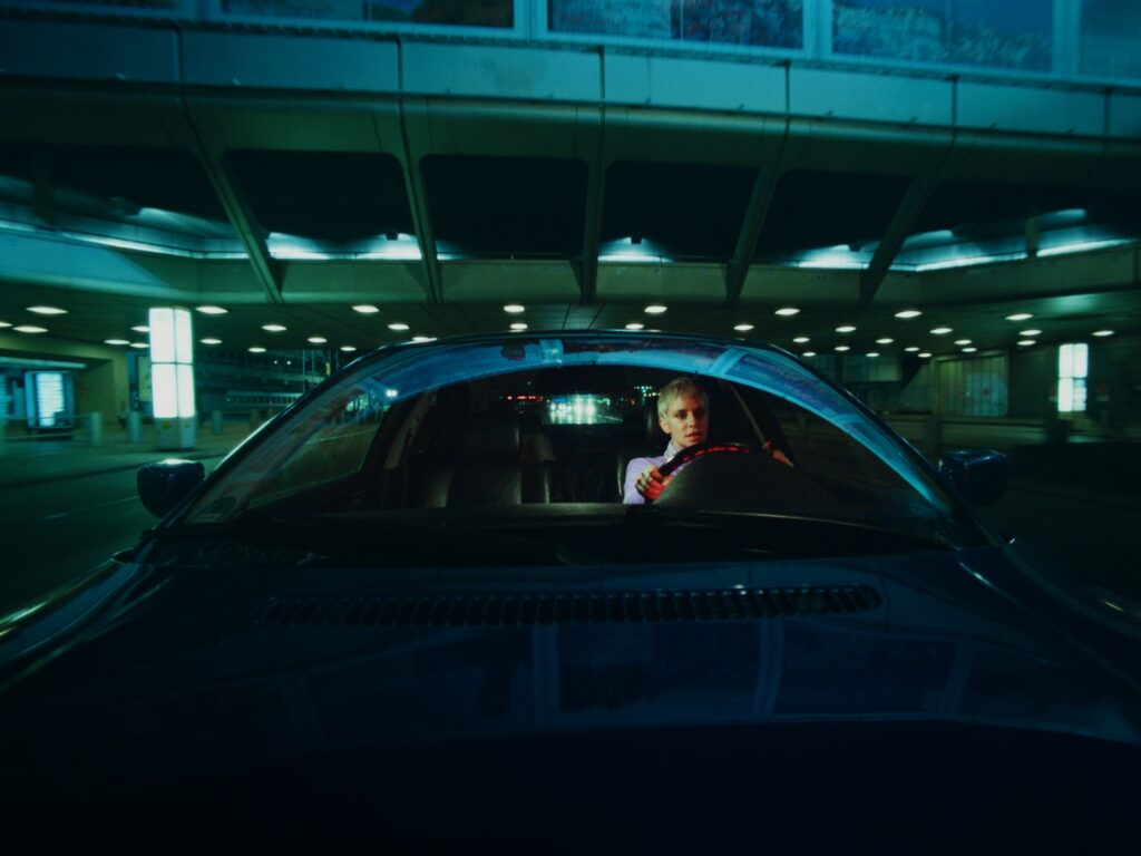 Wide angle shot of a woman driving a car. In the background you see the bokeh which is typical for Zeiss Standard Speed lenses.
