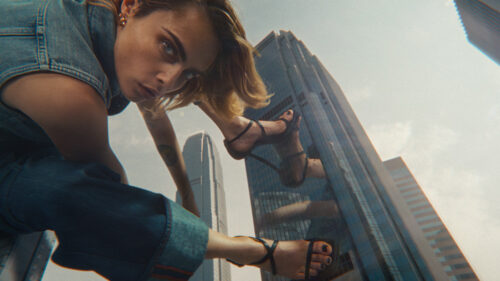 Giant woman in high heels doing yoga on skyscraper facade. Shot on ARRI Ultra Primes. 