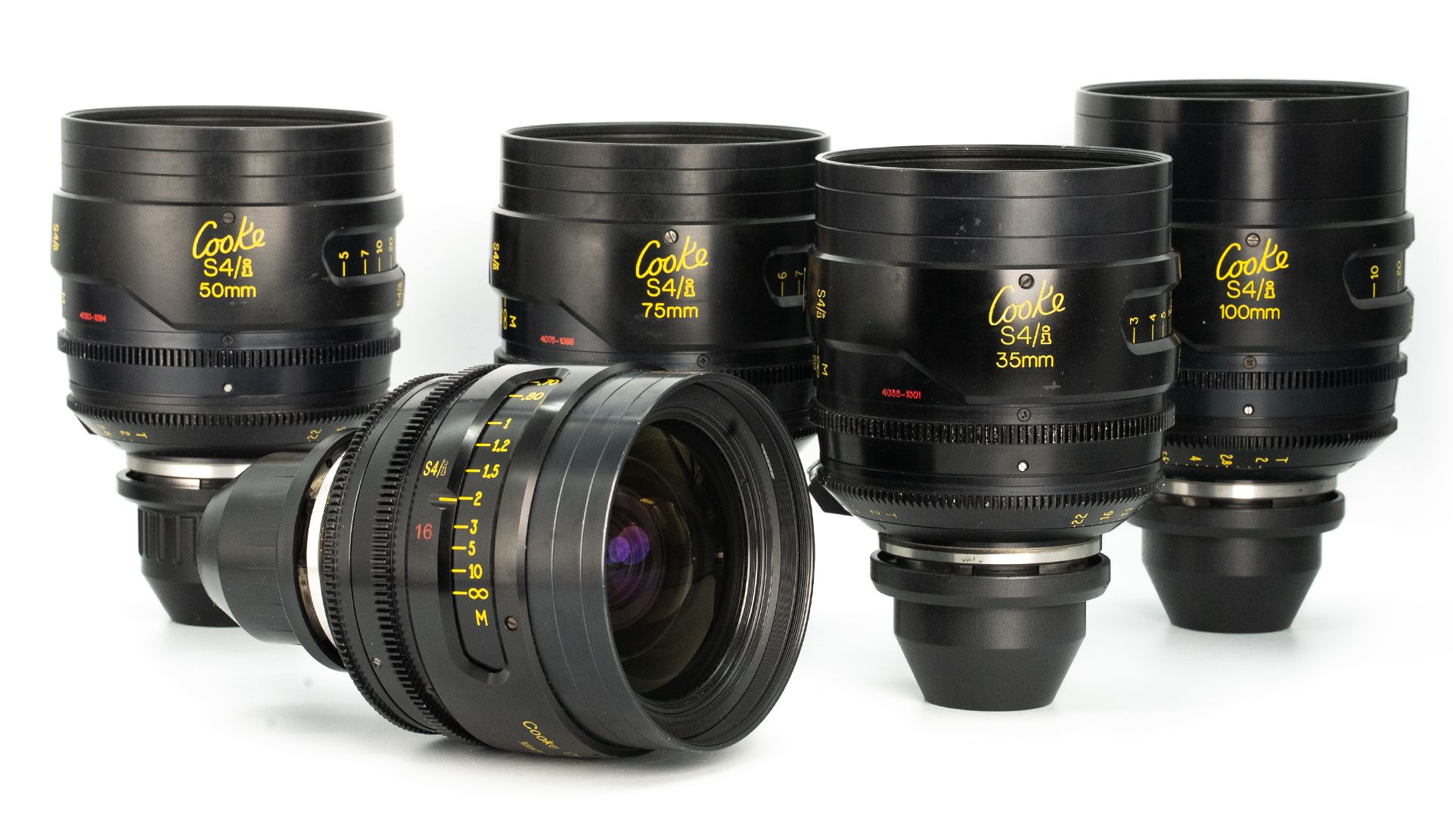 Cooke S4/i cine prime lenses in PL mount, displayed in a group. Visible focal lengths include 35mm, 50mm, 75mm and 100mm. Black housing with yellow engravings, arranged on a white background.
