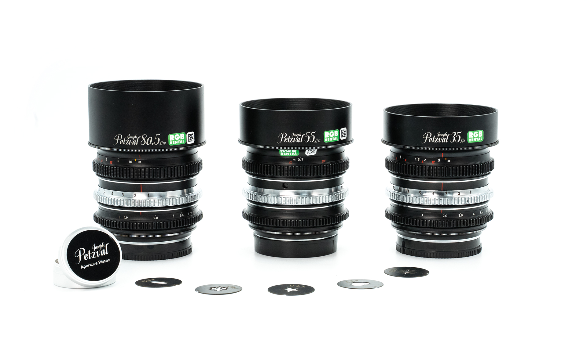 Three rehoused Joseph Petzval cinema lenses (35mm, 55mm, and 80.5mm) with RGB Rental labels displayed on a white background, with decorative aperture plates placed in front of them.